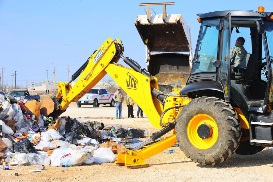 DYESS AIR FORCE BASE, Texas— Senior Airman Korey Seeley, 7th Civil Engineer Squadron, uses a backhoe to sift through a pile of garbage Feb. 22 near the cantonment area here. Dyess firefighters used the backhoe to examine the garbage to make sure the fire had been completely extinguished. To report a fire at Dyess, call 911. For non-emergencies, call (325) 696-2486. (U.S. Air Force photo/Airman 1st Class Courtney Moses) 