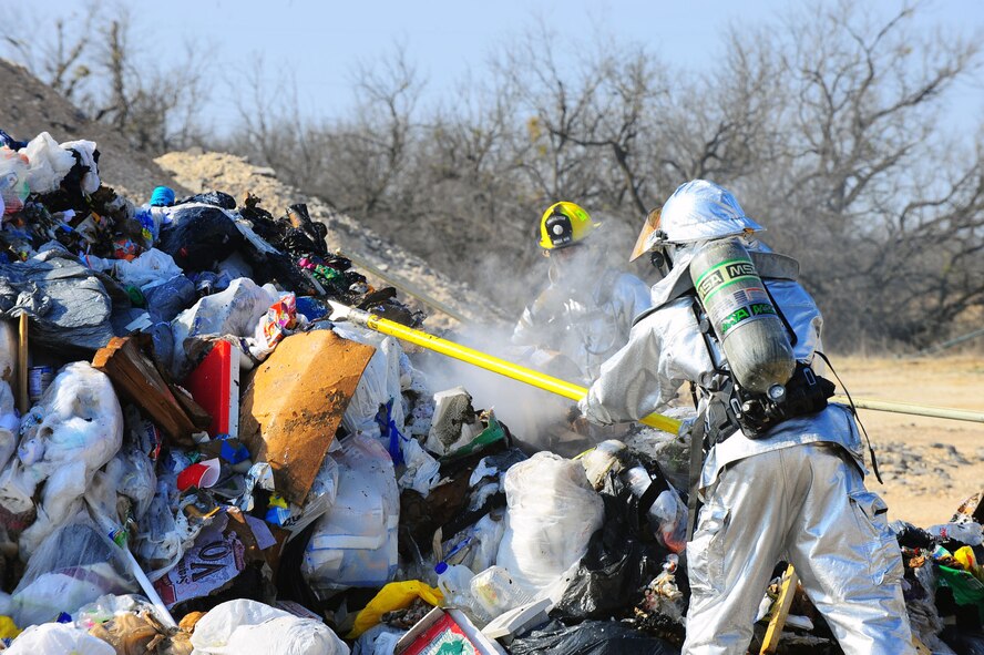 DYESS AIR FORCE BASE, Texas—7th Civil Engineer Squadron firefighters check a pile of garbage to make sure the fire was extinguished Feb. 22 near the cantonment area here. The fire started in a garbage truck, but was moved near the cantonment area to be safely extinguished. To report a fire at Dyess, call 911. For non-emergencies, call (325) 696-2486. (U.S. Air Force photo/Airman 1st Class Courtney Moses)