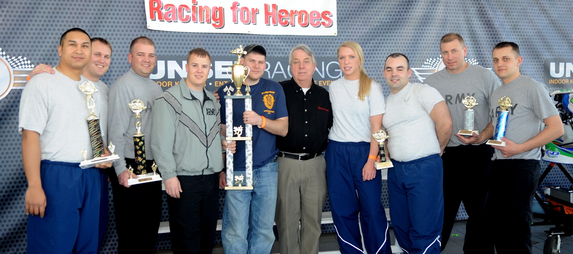 Denver, Colo.- Mr. Craig Mansfield and ten representatives from the Army and Air Force pose for a group shot after racing at Unser Racing track Feb 20, 2011. The Soldiers and Airmen volunteered to show their support in Craig Mansfield's mission to promote awareness to not drink and drive in a new event titled Racing for Hero's. ( U.S. Air Force Photo by Airman 1st Class Marcy Glass)
