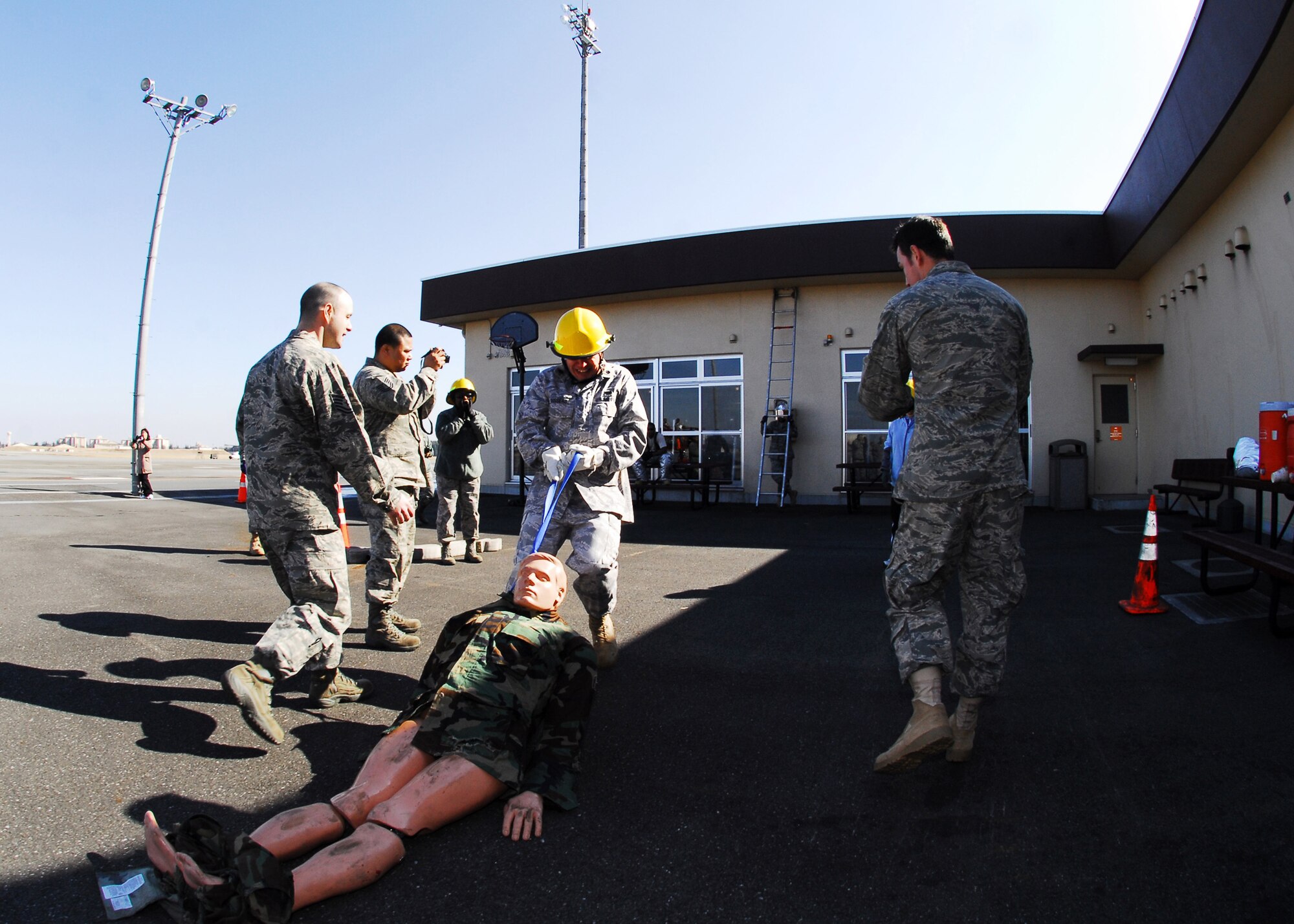 YOKOTA AIR BASE, Japan -- Lt. Col. David Dusseau, 5th Air Force deputy staff judge advocate, carries a 175 pound life-size mannequin as members of his team cheer during a 5th AF team building exercise here Feb. 22.  Six teams participated and the events challenged members' physical fitness levelswhile boosting unit morale.  (U.S. Air Force photo/Airman 1st Class Andrea Salazar)