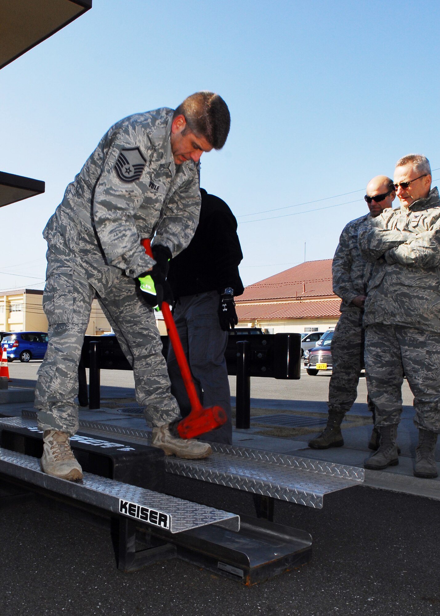 YOKOTA AIR BASE, Japan -- Master Sgt. Fred Itule, 374th Civil Engineer Squadron fire department chief of training, uses a sledgehammer to demonstrate a forced entry challenge during a 5th Air Force team building exercise here Feb. 22.  Firefighters from the 374th CES provided a timed challenge course for 5th AF members that mimicked real fire-ground operations and scenarios such as forced entry, ladder climbing and carrying heavy equipment.  (U.S. Air Force photo/Airman 1st Class Andrea Salazar) 