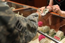 MINOT, N.D. -- Senior Airman Jesse Lopez, 5th Bomb Wing Public Affairs photographer, hands over money to a merchant at a local jewelry store here Feb. 23.  Purchases such as this are how Airmen from Minot Air Force Base contribute to the local community's economy. (U.S. Air Force photo/ Airman 1st Class Aaron-Forrest Wainwright)