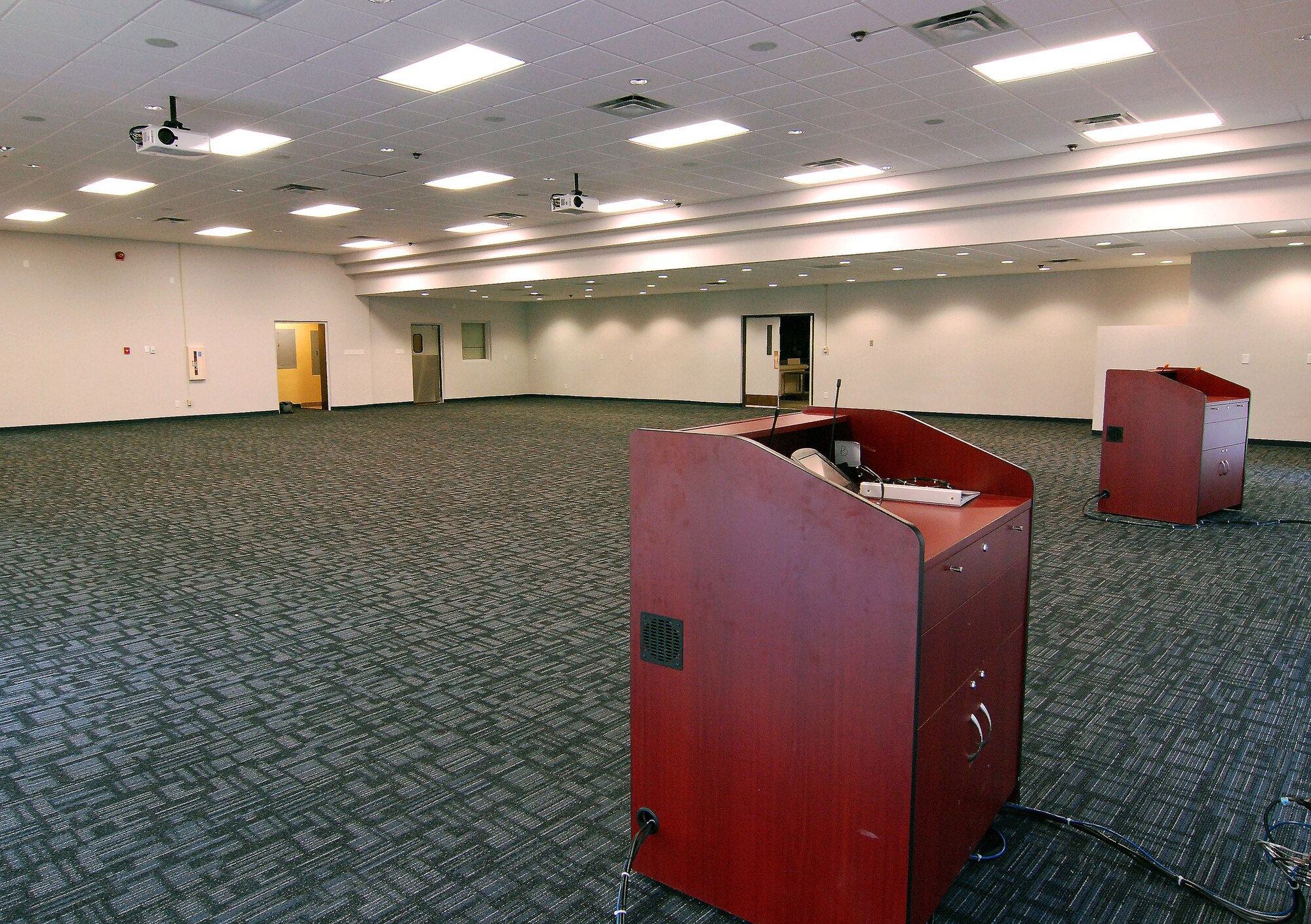 The large meeting room in the newly remodeled Building 813 is brightly lit with fluorescent tubes and energy saving compact fluorescent bulbs, to provide an inviting location for large groups to meet.  There are two podiums with touch screen controls to operate ceiling mounted projectors and screens.  (U.S. Air Force photo/ Brad Fallin)