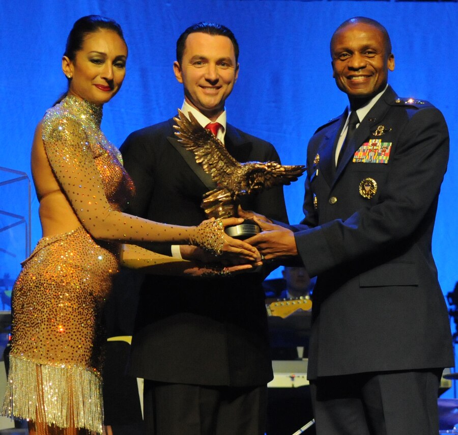 Maj. Gen. Darren W. McDew, commander of the Air Force District of Washington, presents an award to television’s “Dancing With The Stars” Garry Gekhman and his dancing partner, Nancy Flores, at The U.S. Air Force Band’s 2011 Guest Artist Series Feb. 20 at the DAR Constitution Hall, Washington, D.C. Each of the dancers was presented with the award in appreciation of their participation in the concert. (U.S. Air Force photo by Senior Airman Christopher Ruano)