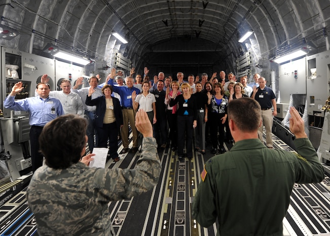 Col. Martha Meeker, left, and Col. John Wood, administer the oath of office to the new Honorary Commanders on board a C-17 Globemaster III Feb. 22 on Joint Base Charleston, S.C. More than 30 local area business people and community leaders became Honorary Commanders of various Air Force and Navy organizations at Joint Base Charleston. (U.S. Air Force photo/Senior Airman Timothy Taylor)