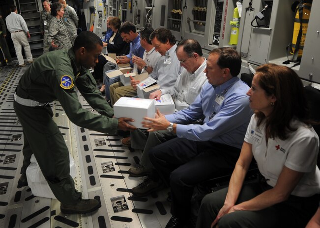 Airman 1st Class Daniel Cherry hands out in-flight meals to Honorary Commanders during their "flight" on a C-17 Globemaster III Feb. 22 on Joint Base Charleston, S.C. Honorary Commanders were given the opportunity to dine on the C-17 and ask the crew questions about the aircraft and their missions. Airman Cherry is a loadmaster with the 14th Airlift Squadron. (U.S. Air Force photo/Senior Airman Timothy Taylor)