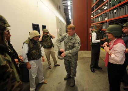 Staff Sgt. Chris Fite illustrates the workings of a combat ready helmet to Honorary Commanders at the Logistics Readiness Squadron warehouse Feb 22 on Joint Base Charleston, S.C. Honorary Commanders were shown items Airmen typically deploy with and received hands on training on how equipment works and feels. Sergeant Fite is the non-commissioned officer in charge of mobility with the 628th LRS. (U.S. Air Force photo/Senior Airman Timothy Taylor)