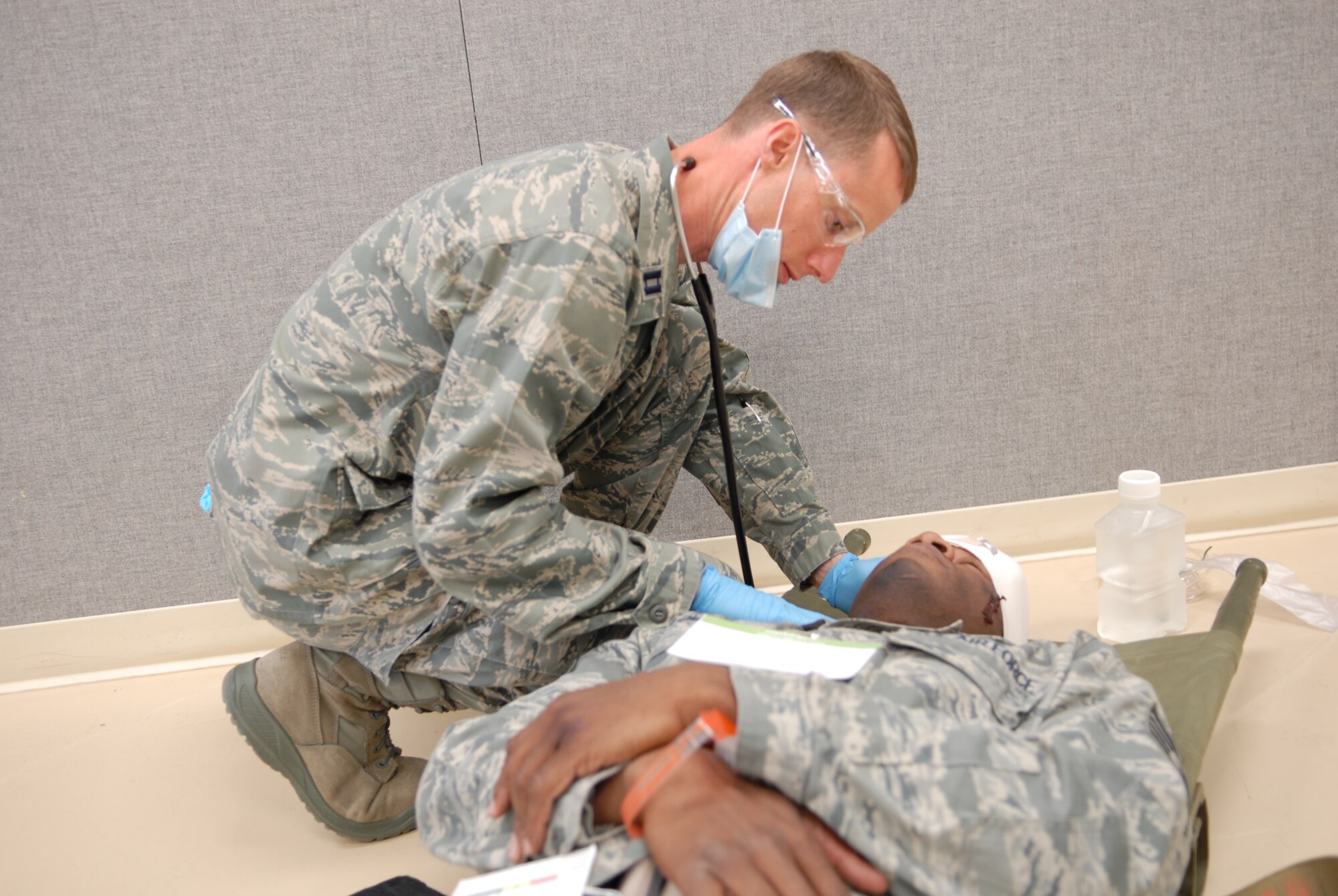 A 95th Medical Group doctor, administers first aid on a victim of a simulated explosion Feb. 14. The exercise started at the Air Force Flight Test Center where a simulated chemical bomb injured more than 50 people. Emergency responders treated and decontaminated the victims and transported them to the 95th Medical Clinic for additional care. (Air Force photo by Senior Airman William A. O'Brien)