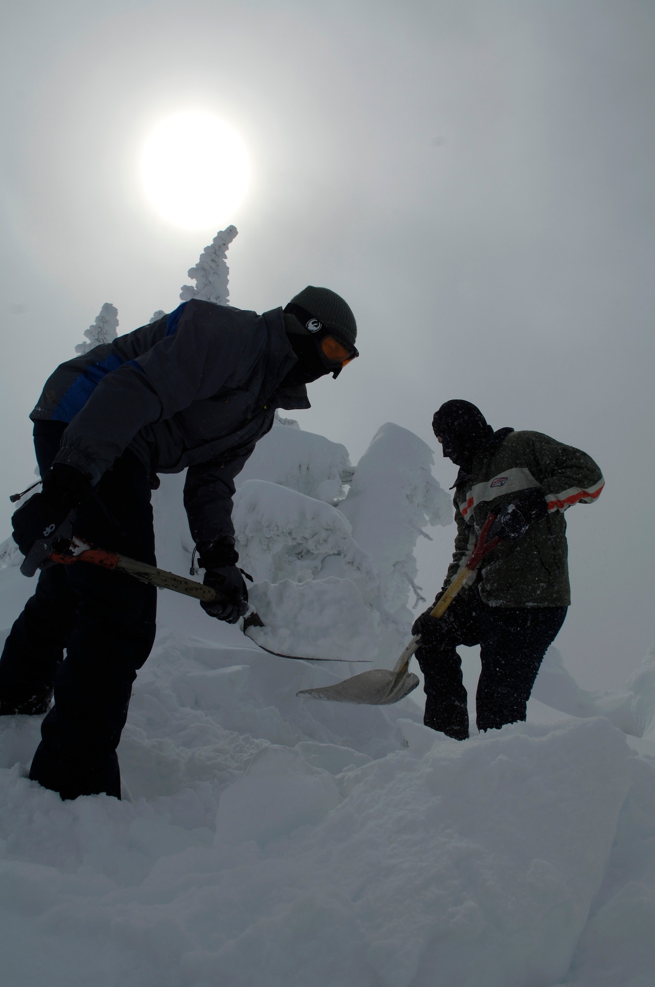 Airman 1st Class Shawn Westbrook and Airman 1st Class Miklos Jeszensky shovel snow to make a drivable path to a radio tower covered with snow and ice Feb. 16, 2011 at the top of the Calispell Mountain Peak in Spokane, Wash.  Both Airmen are transmission systems radio technicians with the 92nd Communications Squadron and are traveling to the radio tower to knock snow and ice off it. Deicing the tower clears radio signals vital to life saving missions done by the 336th Training Group’s rescue flight.  The Airmen began digging this path when their vehicle got stuck a quarter mile away from the tower.  (U.S. Air Force photo/ Senior Airman Natasha E. Stannard)