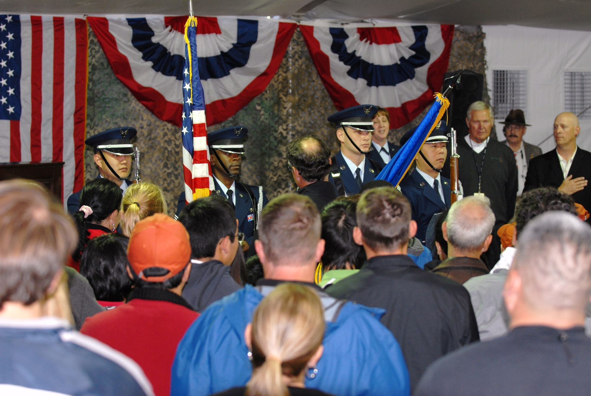 The color guard from March Air Reserve Base presents the colors before a packed audience in the Patriot's Outpost hospitality venue at the Northern Trust Open golf tournament. The hospitality tent was the site of the tournament's Military Appreciation Barbeque Feb. 19. Free food and drinks were provided to servicemembers and their families. Jerry West, pro basketball legend and Executive Director of the NTO, thanked military members for their service. (Air Force photo by Kenji Thuloweit)