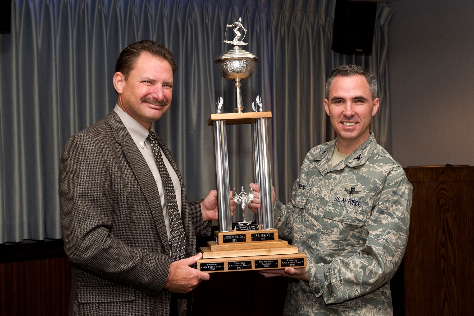 PETERSON AIR FORCE BASE, Colo. – Col. Stephen N. Whiting, 21st Space Wing commander (right), accepts the SnoFest Commander’s Cup Trophy from Dan Schofield, 21st Force Support Squadron deputy, before a recent wing stand-up briefing. Peterson AFB accrued the fastest times on the NASTAR race course during the SnoFest weekend, held Jan. 28 to 30 at Keystone Resort. All Front Range bases participated in this event and this was the third consecutive year Peterson AFB has won the trophy. (U.S. Air Force photo/Craig Denton)