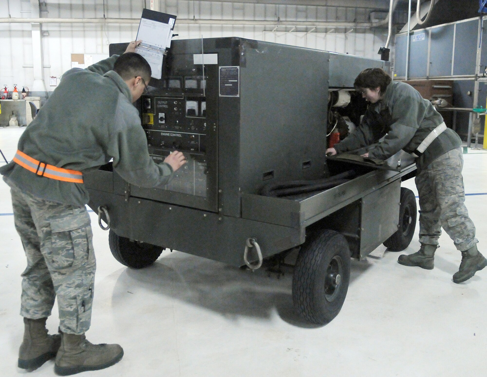 Airmen 1st Class Angel Marquez and Sheldy Forton perform a service inspection on an essex power generator Feb. 16, 2011, at Eielson Air Force Base, Alaska. Airmen periodicaly inspect equipment to ensure it is ready for maintainers to use during aircraft operations. The Airmen are assigned to the 354th Maintenance Squadron as aerospace ground equipment maintainers. (U.S. Air Force photo/Airman 1st Class Janine Thibault)
