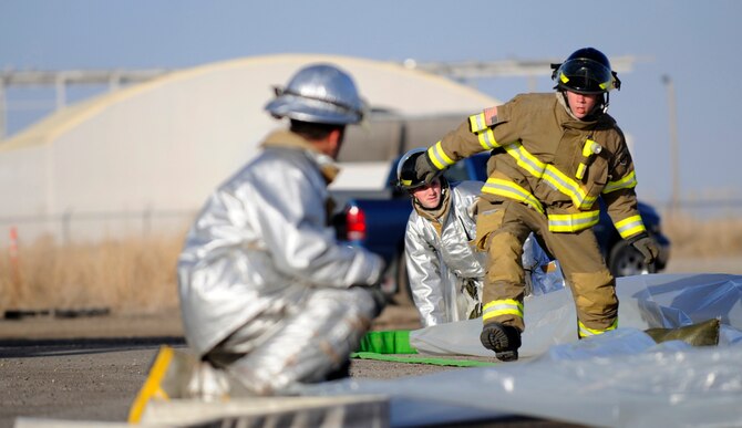MOUNTAIN HOME AIR FORCE BASE, Idaho -- Members of the 366th Civil Engineering Squadron rush to lay down a tarp during a simulated chemical spill for the Unit Compliance Inspection Feb. 15. (U.S. Air Force photo be Airman 1st Class Renishia Richardson) 