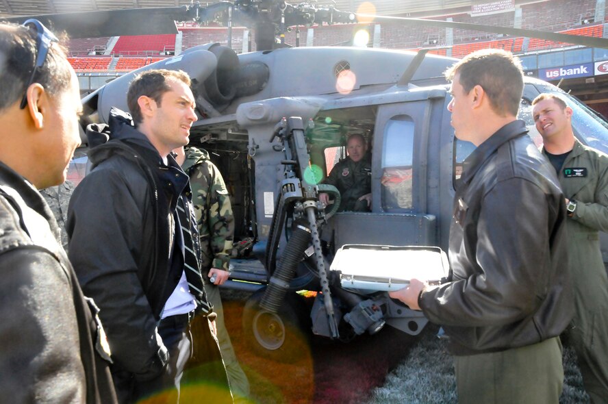 Actor Jude Law greets members from the 129th Rescue Squadron during the making of a movie called "Contagion" at Candlestick Park, San Francisco, Feb. 16, 2011. The 129th Rescue Wing based at Moffett Federal Airfield, Calif., provided an aircrew and HH-60G Pave Hawk helicopter for a movie scene shot at Candlestick Park. (Air National Guard photo by Tech. Sgt. Ray Aquino/RELEASED)
