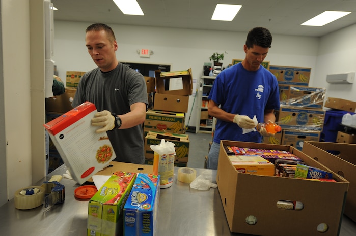 Staff Sgt. Jeffery Van Landingham (left) and Lt. Col. Chad Rauls, inspect donated food items while volunteering at the Low Country Food Bank in Charleston, S.C., Feb. 18. Twenty-five members of the 15th Airlift Squadron volunteered at the food bank for Joint Base Charleston 's Wingman Day, inspecting food, breaking down boxes and re-packing sweet potatoes and pasta into smaller bags for distribution. Sergeant Van Landingham is a loadmaster and Colonel Rauls is a C-17 pilot. (U.S. Air Force photo/ Staff Sgt. Nicole Mickle)