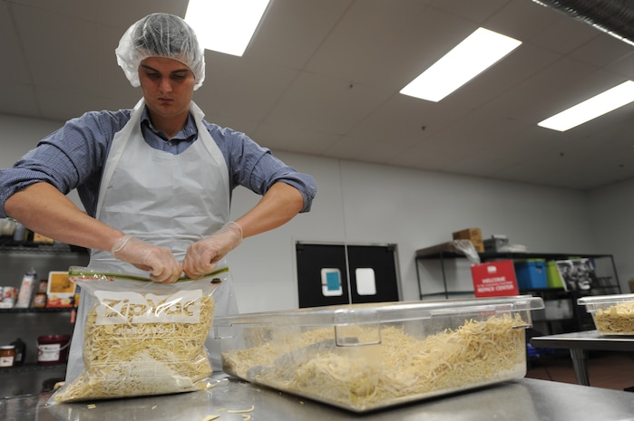 Capt. Kevin Calloway packs a bag of pasta while volunteering at the Low Country Food Bank in Charleston, S.C., Feb. 18, 2011. Captain Calloway was one of 25 members from the 15th Airlift Squadron who volunteered at the food bank during Joint Base Charleston Wingman day. Thanks to their efforts, 4,000 lbs of bulk sweet potatoes  and 4,000 lbs. of pasta were re-packaged into smaller bags for distribution. Captain Calloway is a pilot with the 15 AS. (U.S. Air Force photo/Staff Sgt. Nicloe Mickle)