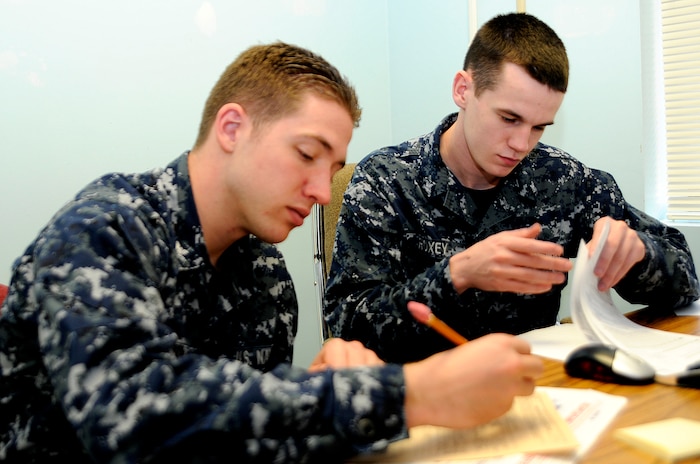 JOINT BASE CHARLESTON, S.C. (February 22, 2011) Machinist’s Mate 3rd Class Jason Roxey, a VITA Tax Center volunteer, looks over tax documents for Machinist’s Mate 3rd Class James Womack as he fills out a tax form at Joint Base Charleston-Weapons Station, Feb. 22.  The VITA tax center, in building 206 on JB Charleston-WS, is open Tuesday through Friday 7a.m. to 7p.m. and on Saturdays from 9a.m. to 3p.m. The VITA tax center is for Active duty, Reserve, and dependants that need assistance filling their federal and state taxes and are assisted on a walk-in basis, no appointments required.  The JB Charleston- Air Base tax center is located at 205 South Davis drive, building 246, room 125, and takes appointments from 8a.m. to 3p.m.. (U.S. Navy photo/Machinist’s Mate 3rd Class Brannon Deugan)