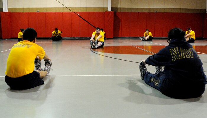 Gas Turbine System Technician- Mechanical 1st Class Michael Neubauer, (center), an instructor for the Center for Personal and Professional Development learning site at Mayport, Fla., leads participants of the Bearings Course in some stretching exercises during a group physical training event at Joint Base Charleston-Weapons Station, Feb. 16.  (U.S. Navy photo/Machinist’s Mate 3rd Class Brannon Deugan)