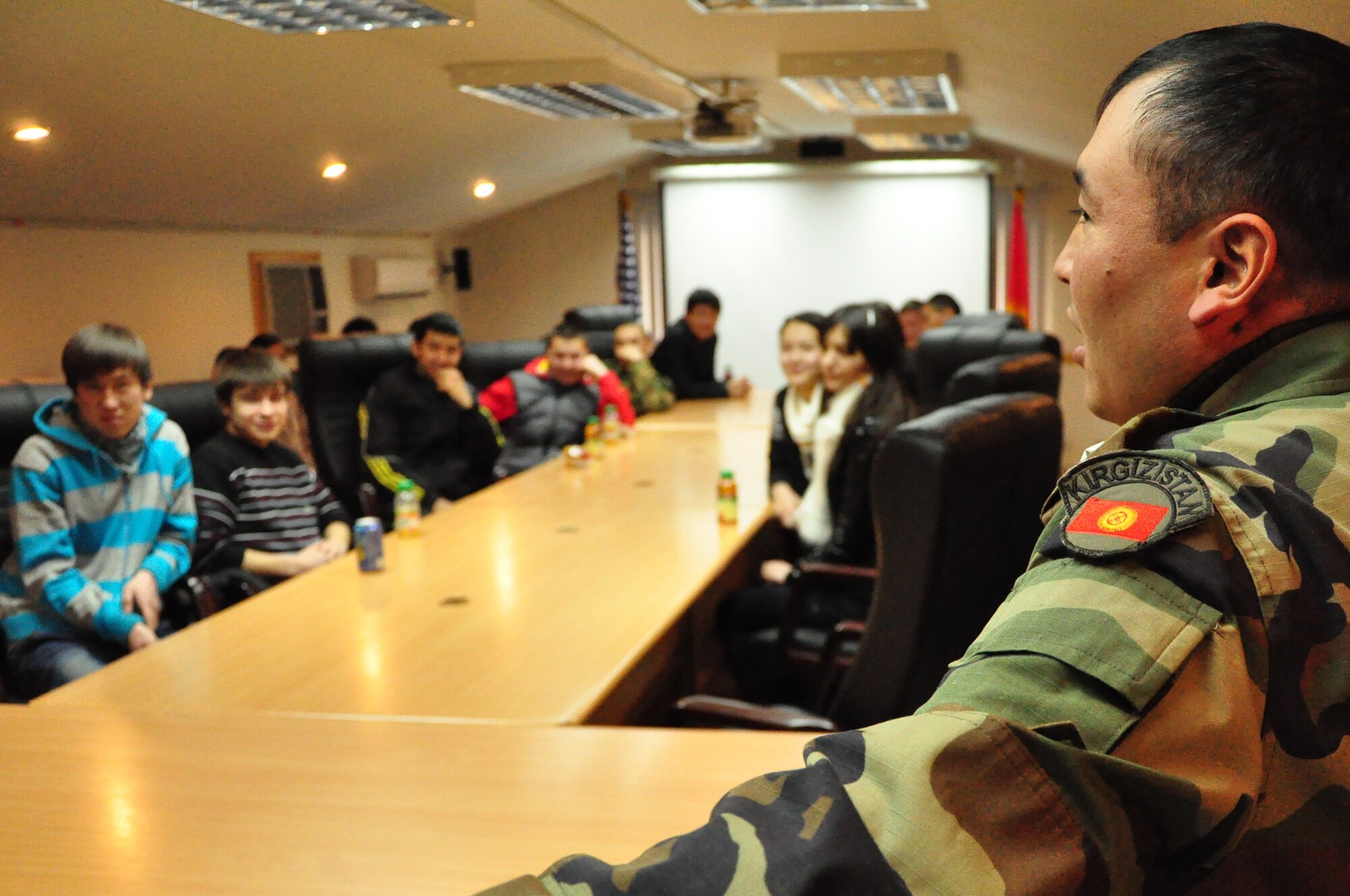 Maj. Ularbek Kazakov  from the Koi Tosh Sergeants School briefs students from Leninskoye village about life in the Kyrgyz military. The students were part of a first-ever Kyrgyz-U.S. Military Orientation Day at the Transit Center Feb 22. After briefings on life in both countries’ services, the students were given a tour on various aspects of the Transit Center  as well as the C-17 Globemaster III and KC-135 Stratotanker. (U.S. Air Force photo/Master Sgt. Daniel Nathaniel)