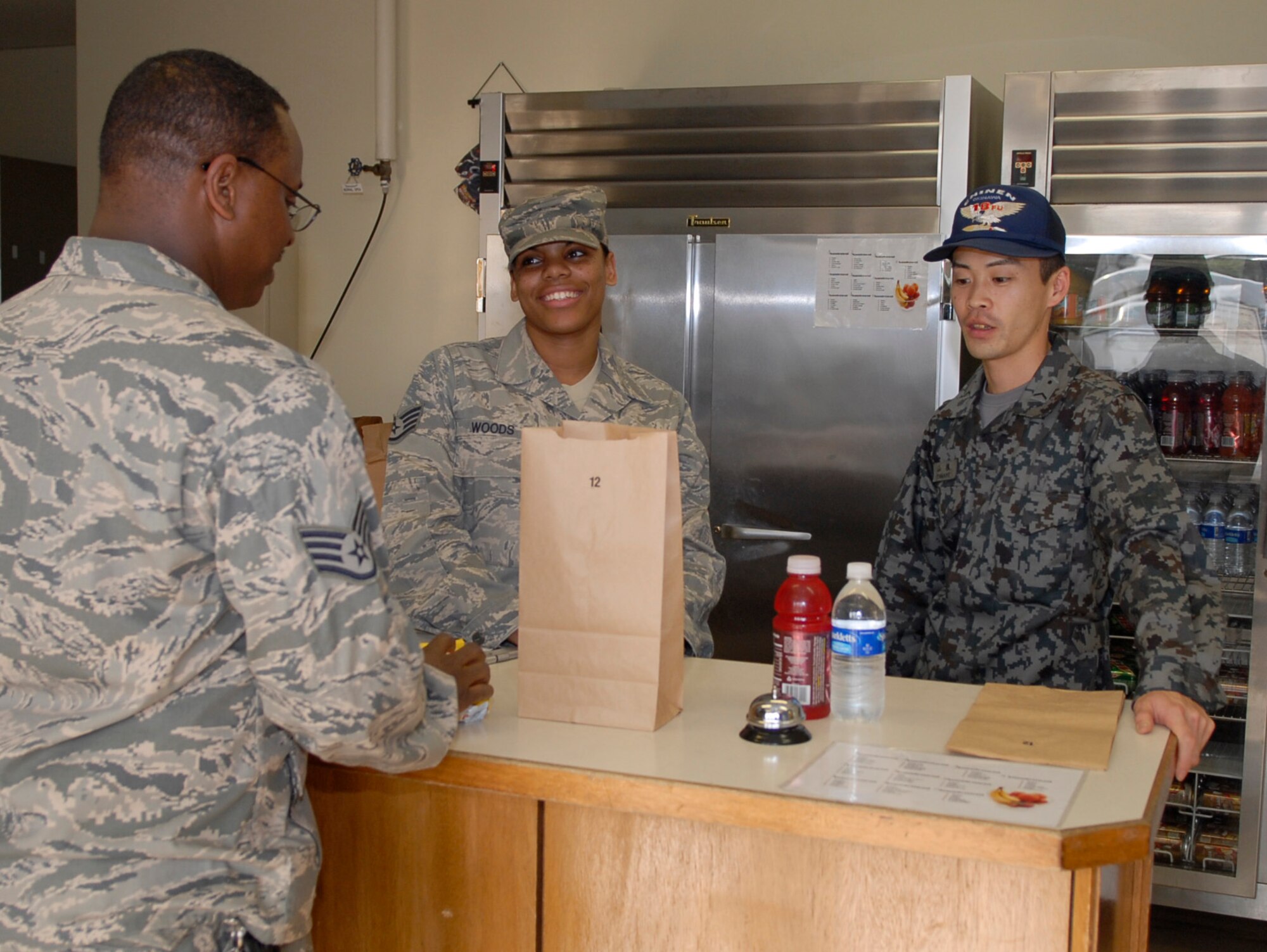 Staff Sgt. Talandra Woods, non-commissioned officer in charge of the Johnson Dining Facility, and Staff Sgt. Naoki Yamane, a Japanese Air Self Defense Force food service specialist, prepare an order for a customer. Sergeant Woods and Sergeant Yamane participated in an NCO exchange program to learn more about how each other operates in their workcenters. (U.S. Air Force photo/Airman 1st Class Tara A. Williamson)