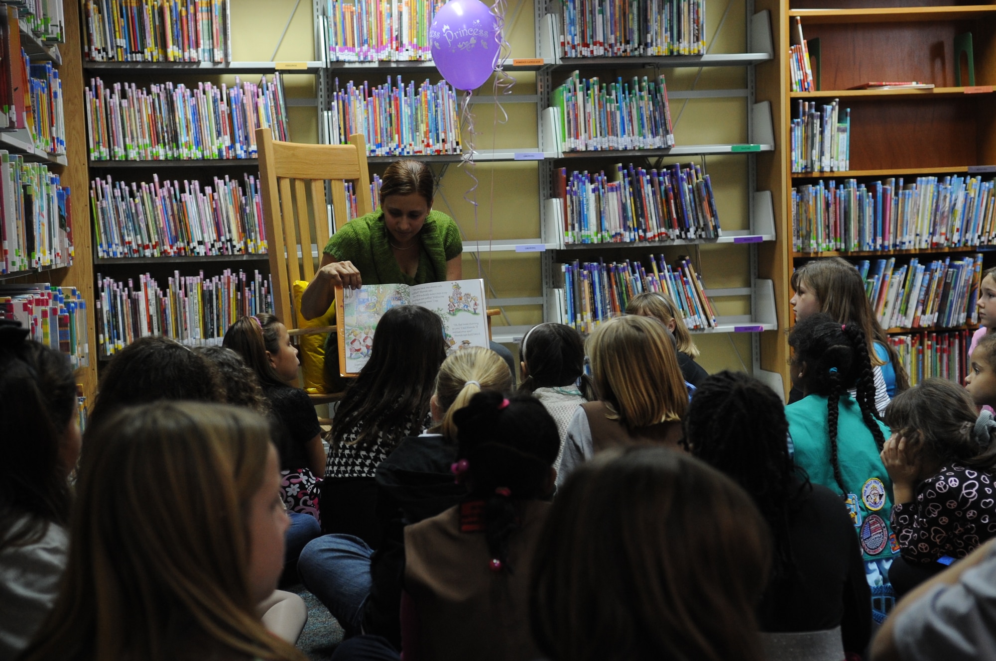 Zulma Perez , 39th Force Support Squadron base library technician, reads a story to the participants at the Fancy Nancy Tea Party Feb. 15, 2011, at Incirlik Air Base, Turkey. The tea party was held at the base library for girls ages 6-10 to help promote and continue community involvement with the children on Incirlik. The participants received tiaras, sunglasses, necklaces and feather boas. The girls also made purses and wands during the event. (U.S. Air Force photo by Airman 1st Class Clayton Lenhardt)