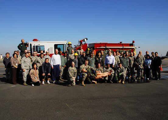 YOKOTA AIR BASE, Japan -- 5th Air Force members pose with the 374th Civil Engineer Squadron fire department after completing a team building exercise here Feb. 22.  374th CES assisted 5th AF personnel by providing a firefighter challenge course that tested their ability to work quickly and effectively as a team.  (U.S. Air Force photo/Airman 1st Class Andrea Salazar)
