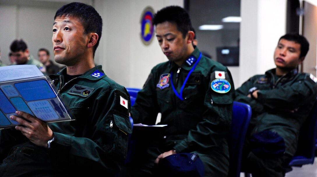 Japanese Air Self-Defense Force pilots listen as U.S. Air Force Lt. Col. Rob Monberg briefs aircraft crew participating in a joint formation over Andersen Air Force Base, Guam, Feb. 21, 2011. Monberg is a U.S. Air Force F-16 Fighting Falcon pilot assigned to the 18th Aggressor Squadron. 