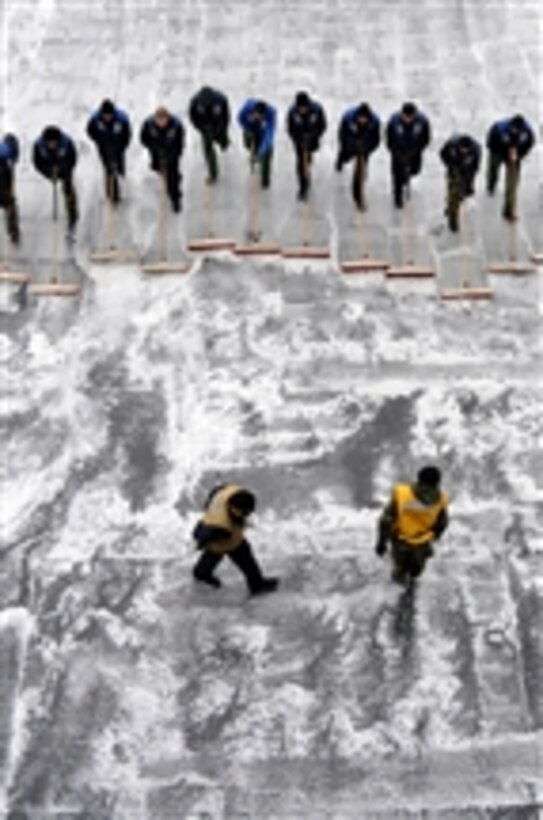 Sailors assigned to the aircraft carrier USS George H.W. Bush (CVN 77) participate in a scrubbing exercise on the ship's flight deck while underway in the Atlantic Ocean on Feb. 22, 2011.  The George H.W. Bush is conducting training operations.  
