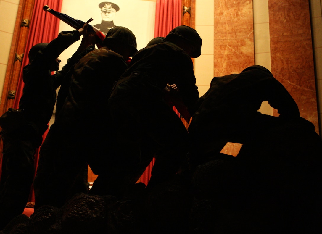 A detail of high school students with Central Indiana Young Marines reenact the famous Mount Suribachi flag-raising during the First Annual Iwo Jima Memorial Service at the Indiana War Memorial Museum Feb. 23.  Detachment 1, Communications Company, Headquarters and Service Battalion, 4th Marine Logistics Group invited more than a dozen Iwo Jima Marine veterans from across Indiana to the event to honor their service on Iwo Jima.