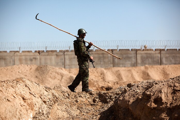 An Afghan National Army soldier with Route Clearance Company, 1st Brigade, 215th Corps, scours an improvised explosive device course at Camp Dwyer, Helmand province, Afghanistan, Feb. 23.