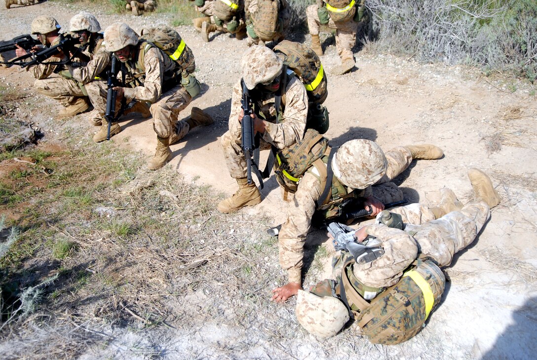 A Company D recruit provides first aid for a fellow recruit after a simulated improvised explosive device goes off Feb. 22, during the Crucible at Weapons and Field Training Battalion, Camp Pendleton, Calif. When detonated, a simulated IED releases a cloud of white powder that marks recruits near it, simulating combat casualties.