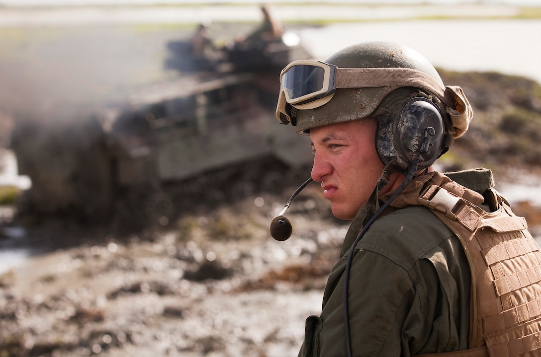 Lance Cpl. Michael Haus, an amphibious assault vehicle crewman with AAV Platoon, Combat Assault Company, 3rd Marine Regiment, sits near the front of his AAV and watches as others tear up invasive pickleweed in the Nuupia Ponds Wildlife Management Area during the 29th annual Mud Ops exercise on Marine Corps Base Hawaii, Feb. 23, 2011. The 29-year-long Mud Ops tradition partnered AAV Platoon Marines with the base Environmental Compliance and Protection Department to prepare the 517-acre area for the upcoming breeding season of the endangered Hawaiian stilt bird species, which lasts from March until September.