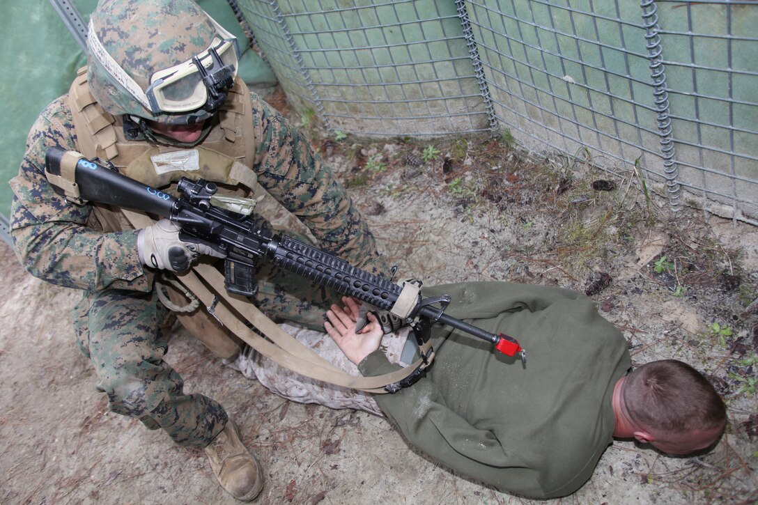 Cpl. A.J. Stanich, a Marine with 2nd Platoon, Battery B, 2nd Low Altitude Air Defense Battalion, shoves another Marine role playing as a terrorist onto the ground during the terrorist’s attempt to infiltrate the entry control point with an improvised explosive device near Landing Zone Lark, Marine Corps Base Camp Lejeune, N.C., Feb. 24. The ability to properly man an entry control point is vital to the security of a forward operating base.