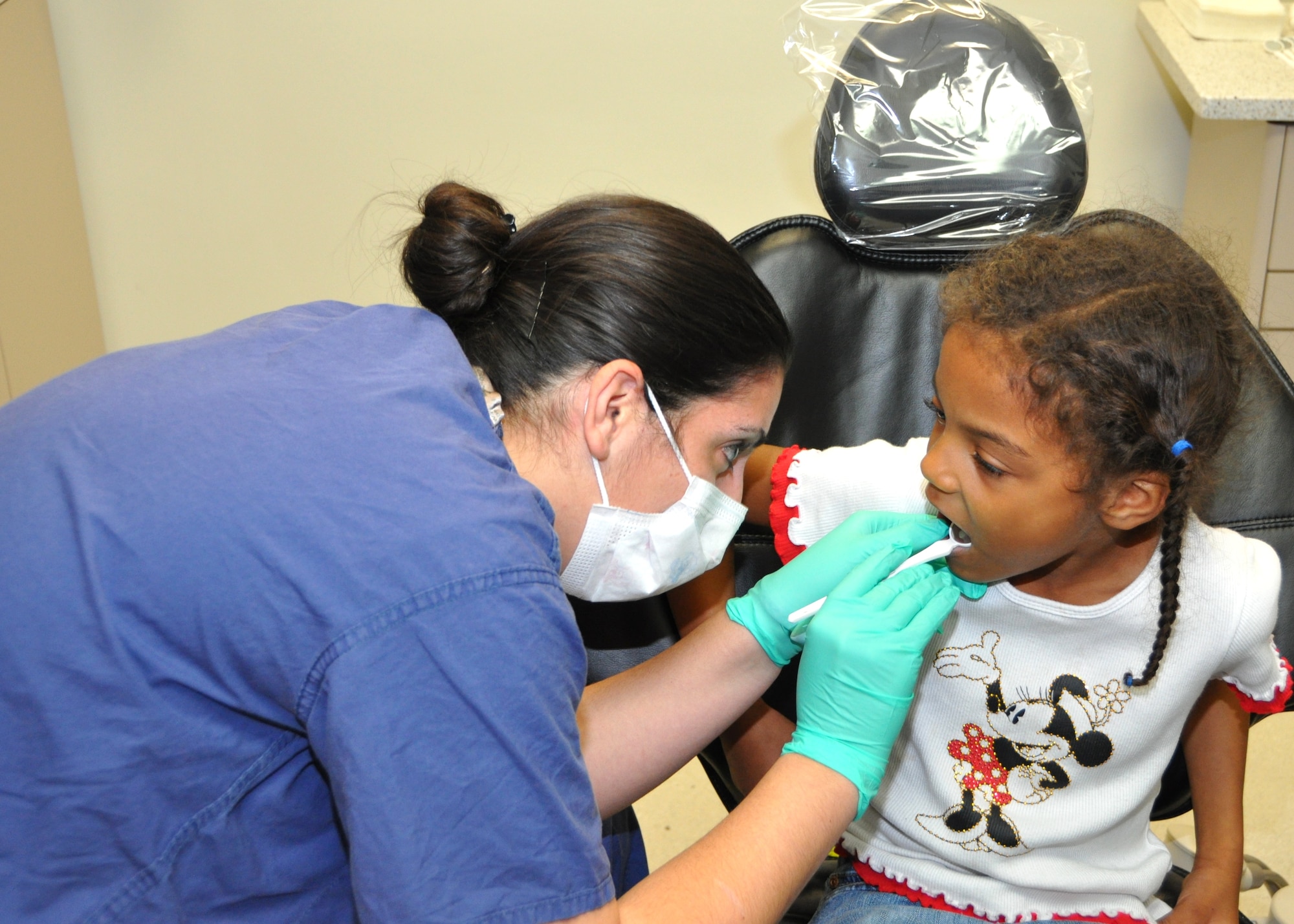 Capt. (Dr.) Erin McNamara examines Tabitha Smith’s teeth during the Feb. 4 “Give Kids A Smile” Day. Tabitha, 6, is the daughter of Suzette and the late Clive Smith, a retired soldier.  (U.S. Air Force photo by Steve Pivnick)