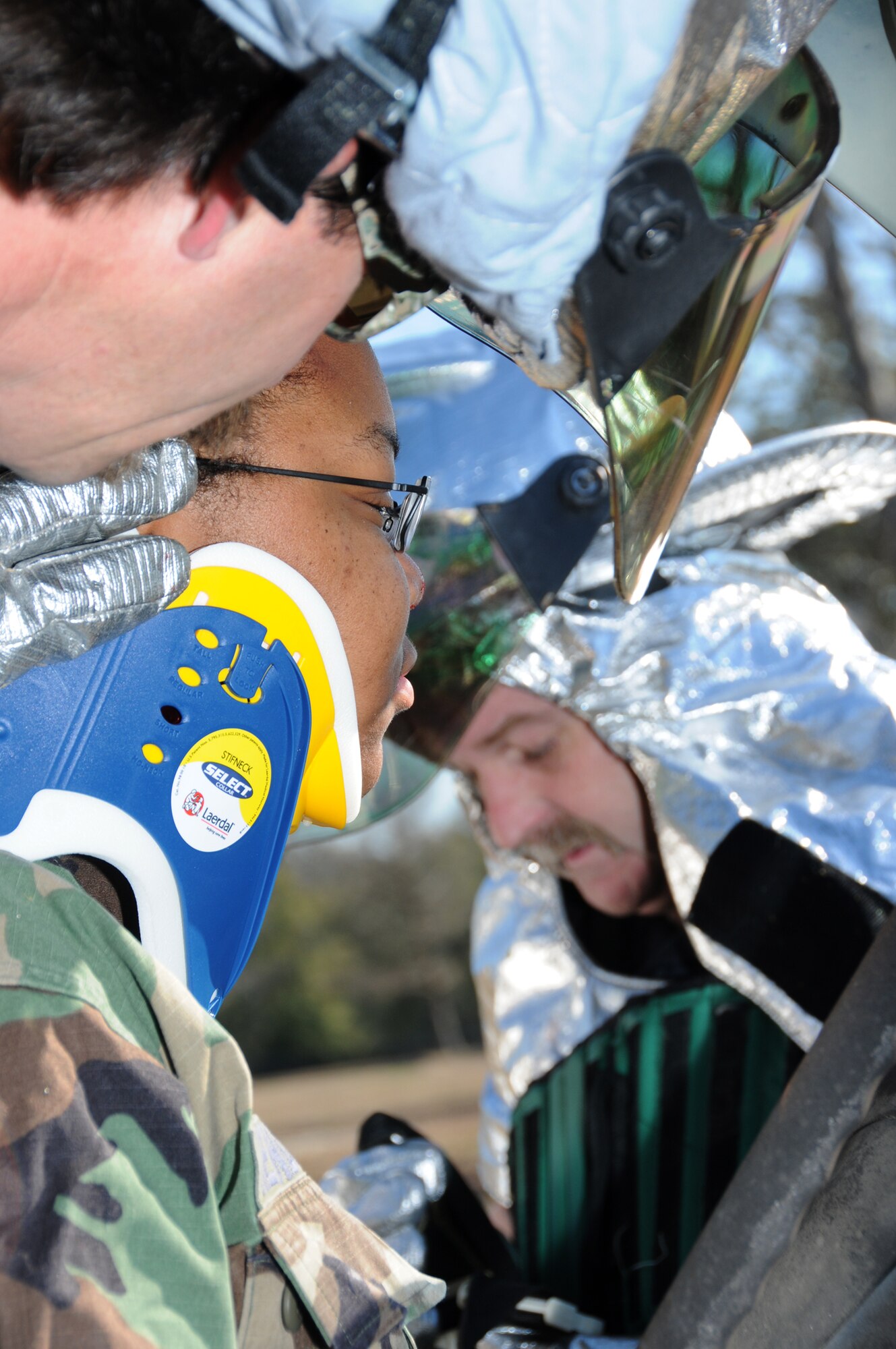 Keesler firefighters David Cleland, left, and Donavan Oosterhuis, right, work to stabilize Airman Basic Latoya Shepherd before removing her from a vehicle to receive medical care. Airman Shepherd is a student in the 336th TRS.  (U.S. Air Force photo by Kemberly Groue)