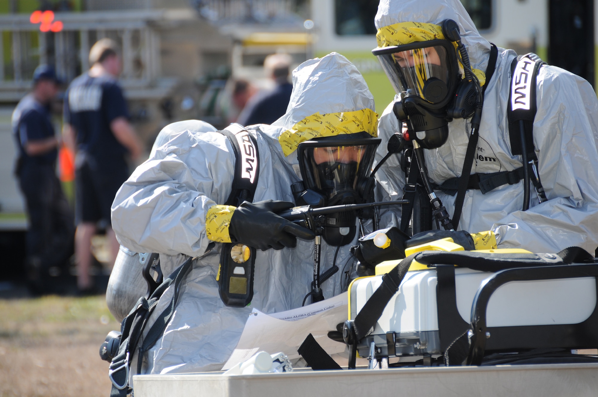 Senior Airman Harold Tamondong, left, and Airman 1st Class Greg Rollings, 81st AMDS environmental flight, work together at the crash site to identify potential hazards in order to recommend personal protective equipment for the clean-up
crew and emergency responders.  (U.S. Air Force photo by Kemberly Groue)