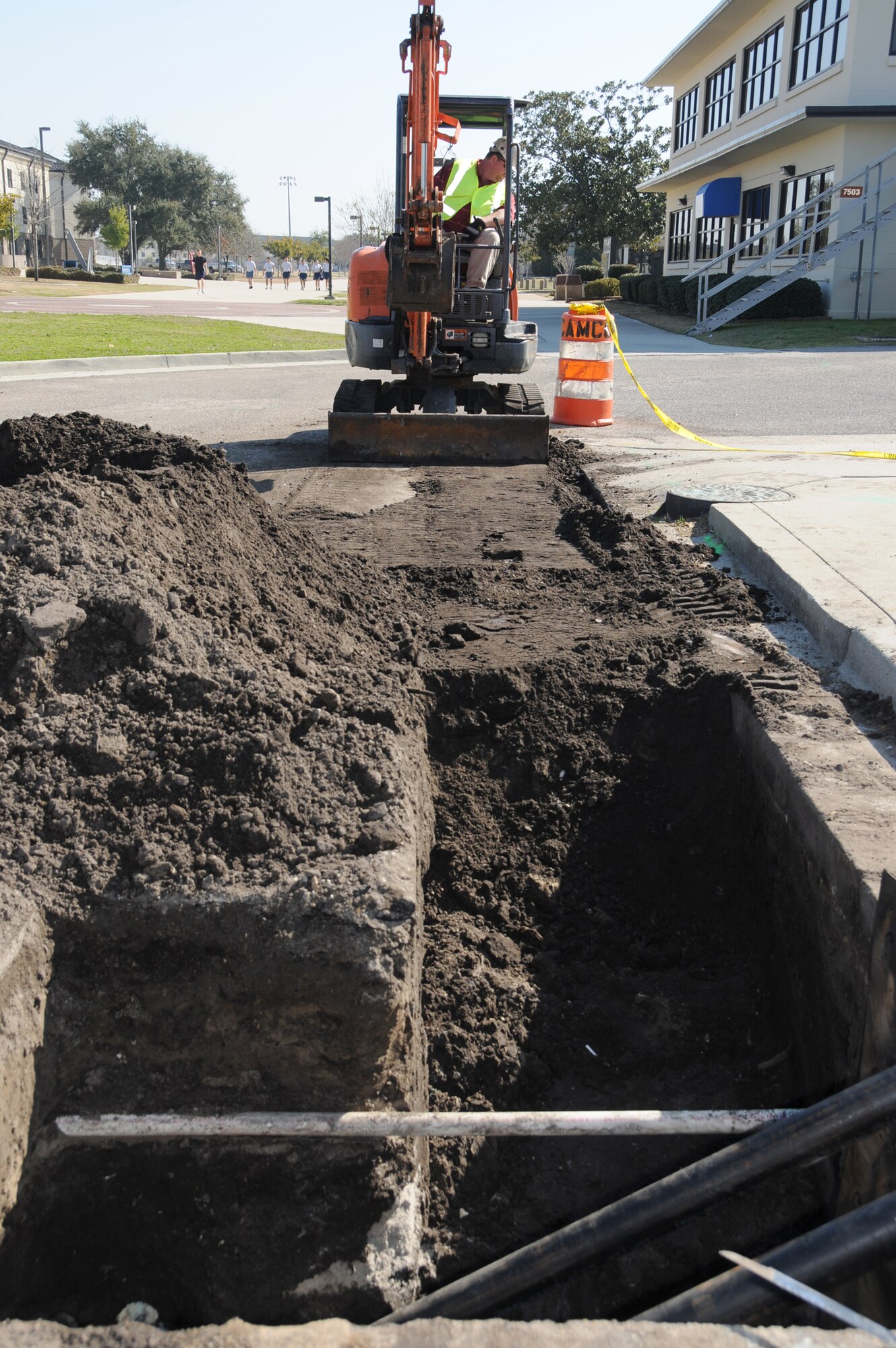 Dennis Mason from Shackleford Plumbing prepares a ditch for pipefitting for the Triangle’s chilled water loop project in front of Triangle Fitness Center, Feb. 15.  (U.S. Air Force photo by Kemberly Groue)