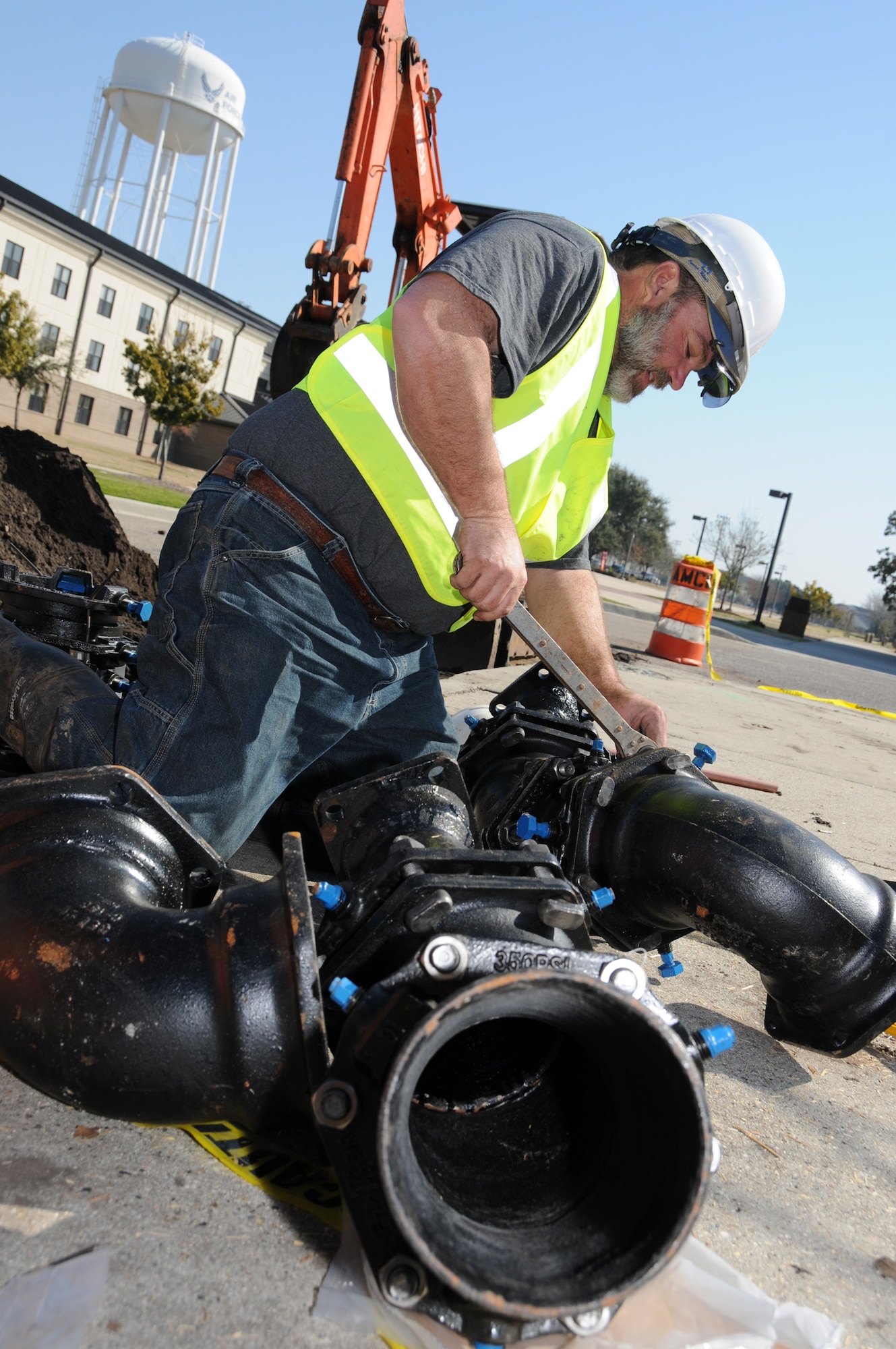 Doug Ferrell from Shackelford Plumbing assembles chill water pipe fittings Feb. 15 in front of theTriangle Fitness Center. Keesler has garnered $2.5 million for two projects that will reduce the base’s energy consumption. The chilled water loop project will increase cooling reliability and cut 165,000 kilowatt hours from the base’s monthly electric bill, saving Keesler nearly $140,000 annually. The lighting modernization project will reduce energy consumption and improve lighting conditions in 16 buildings across the base.  (U.S. Air Force photo by Kemberly Groue)