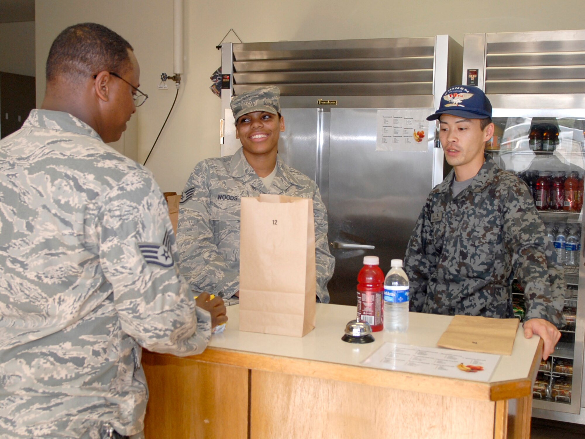 Staff Sgt. Talandra Woods and Japanese Air Self Defense Force Staff Sgt. Naoki Yamane prepare an order for a customer Feb. 23, 2011, at Kadena Air Base, Japan. Sergeant Woods and Sergeant Yamane participated in an NCO exchange program to learn more about how each other operates in their workcenters. Sergeant Woods is the NCO in charge of the Johnson Dining Facility at Kadena AB. Sergeant Yamane is a JASDF food service specialist. (U.S. Air Force photo/Airman 1st Class Tara A. Williamson)