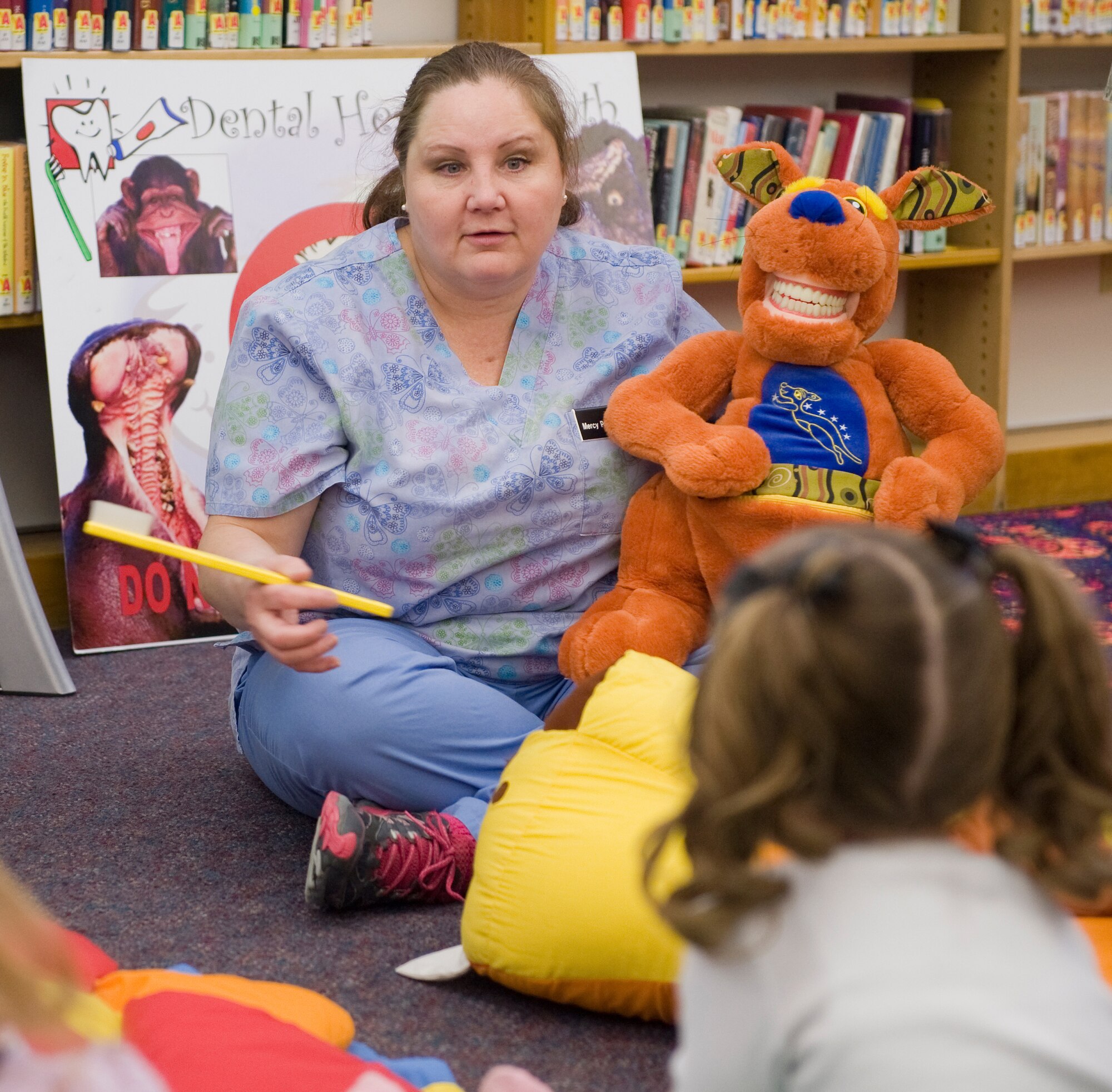 Dental technician Mercy Padgett explains to the children participating in preschool story hour at the library some of the things she will talk with them about for her Children's Dental Health Month presentation Feb. 18. February is National Children's Dental Health Month. (U.S. Air Force photo/Beau Wade)