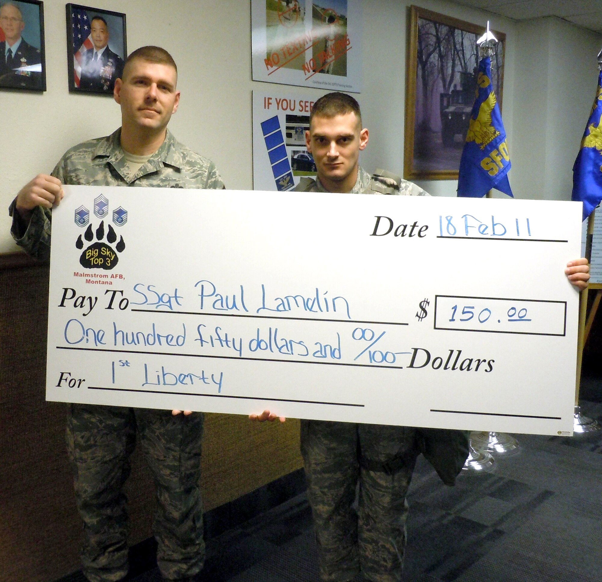 Master Sgt. Anthony Blum, a Top 3 Council member, presents Staff Sgt. Paul Lamelin a check for $150 to be used towards furthing his education. (U.S. Air Force courtesy photo)