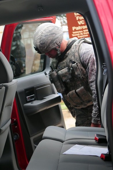 Airman 1st Class Jesse Dixon, 2nd Security Forces Squadron, inspects the interior of a vehicle at the West Gate located at Barksdale Air Force Base, La., Feb. 24. Random vehicle inspections were conducted as part of force protection measures during a Conventional Operational Readiness Exercise. (U.S. Air Force photo/Senior Airman Joanna M. Kresge)