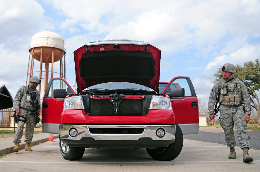 Staff Sgt. Derek Rucker  and Airman 1st Class Jesse Dixon, 2nd Security Forces Squadron, inspect a vehicle at the West Gate located at Barksdale Air Force Base, La., Feb. 24. Random vehicle inspections were conducted as part of force protection measures during a Conventional Operational Readiness Exercise. (U.S. Air Force photo/Senior Airman Joanna M. Kresge)