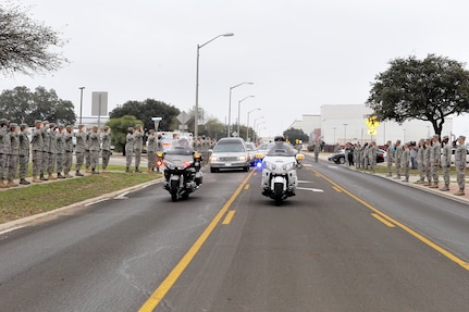 Men and women from Lackland line the street Feb. 24 as a show of respect for Airman 1st Class Corey C. Owens, an Airman from San Antonio who died Feb. 17 during a deployment to Al Asad Air Base, Iraq. Airman Owens was assigned to the 47th Security Forces Squadron, Laughlin Air Force Base, Texas. (U.S. Air Force photo/Tony Morano) 