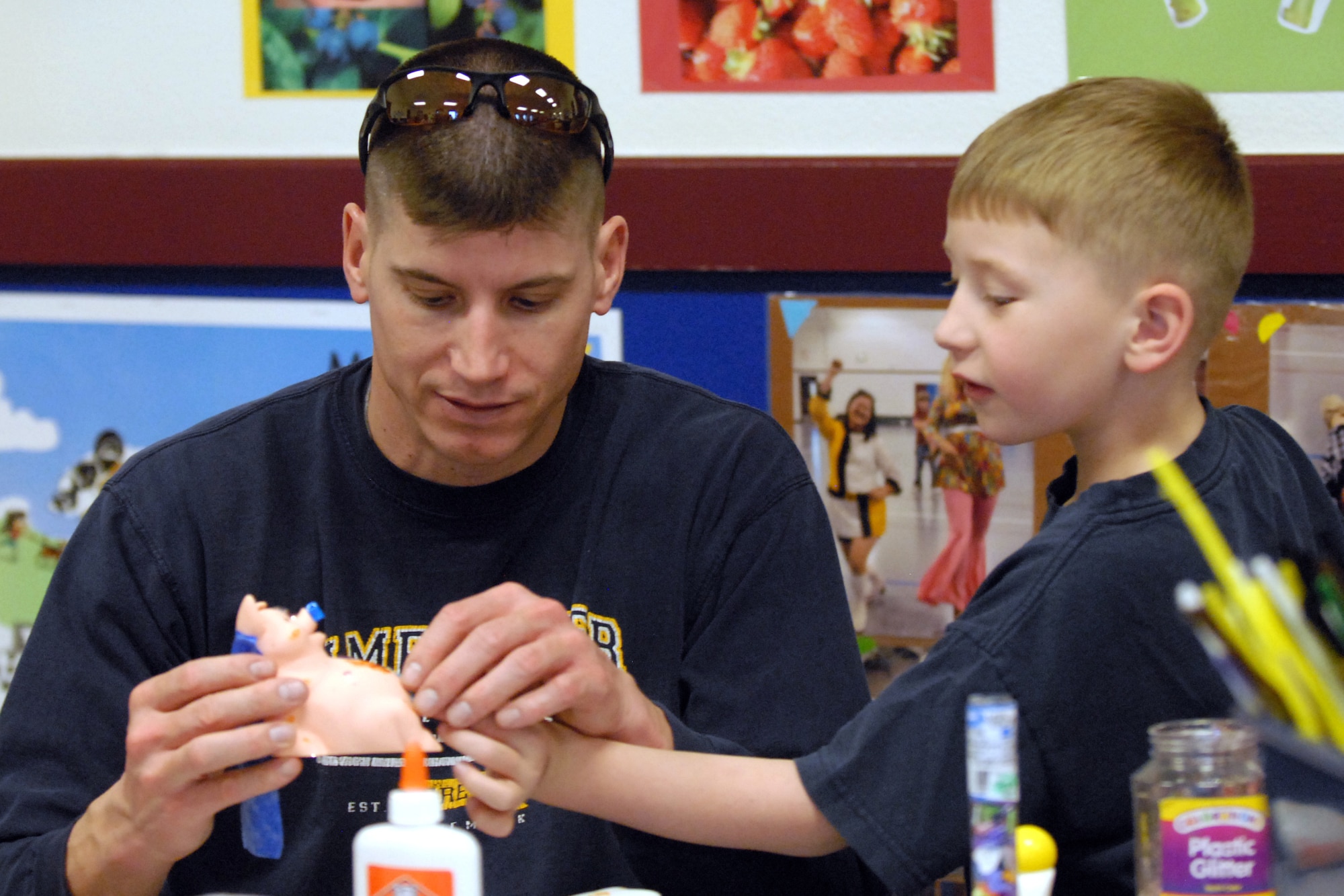 Tech. Sgt. Kevin Lambert, 20th Air Force, and his son Ryan, 6, decorate a piggy bank as part of Warren’s Youth Center family craft night Feb. 18. The base’s Airman & Family Readiness Center sponsored a piggy-bank decorating contest as part of Military Youth Saves campaign, which is designed to encourage children and teens to develop good saving habits. (U.S. Air Force photo by R.J. Oriez)