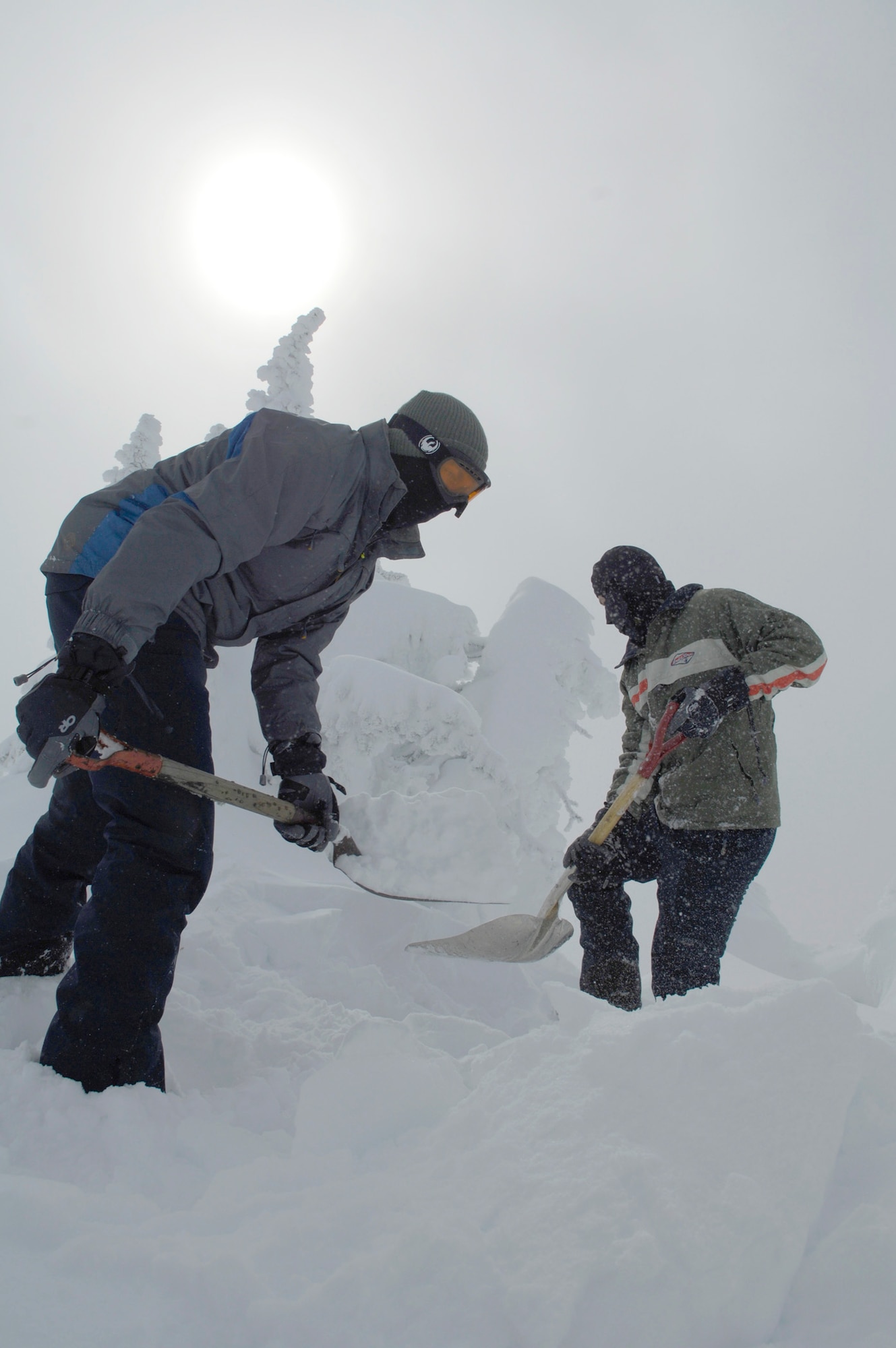 Airmen 1st Class Shawn Westbrook and Miklos Jeszensky shovel snow to make a drivable path to a radio tower covered with snow and ice Feb. 16, 2011, at the top of the Calispell Mountain Peak in Spokane, Wash. Both Airmen are transmission systems radio technicians with the 92nd Communications Squadron at Fairchild Air Force Base, Wash., and are traveling to the radio tower to knock snow and ice off it. Deicing the tower clears radio signals vital to life-saving missions done by the 336th Training Group's rescue flight. The Airmen began digging this path when their vehicle got stuck a quarter mile away from the tower. (U.S. Air Force photo/Senior Airman Natasha E. Stannard) 
