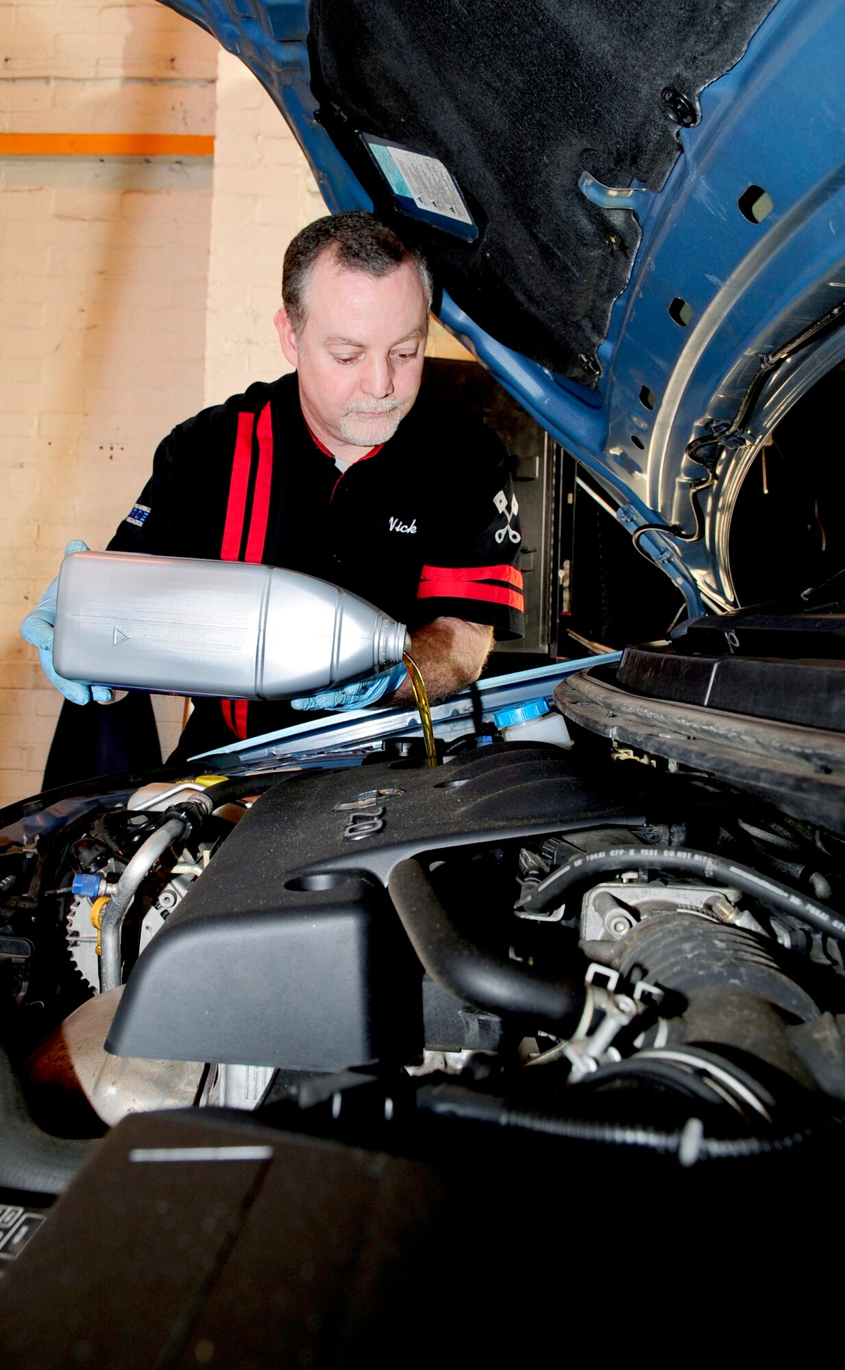 RAF MILDENHALL, England -- Nick Turmaine, 100th Force Support Squadron Auto Hobby Complex employee, refills the oil of a vehicle after an oil change Feb. 24, 2011. The shop employees offer a free bi-weekly class for ladies to teach them the basics of car maintenance such as how to change a tire, fluid levels and safety must knows. The next class will be held March 16. The auto hobby complex will provide automotive maintenance for the cost of parts plus labor fees at $60 per hour. (U.S. Air Force photo/Senior Airman Ethan Morgan)