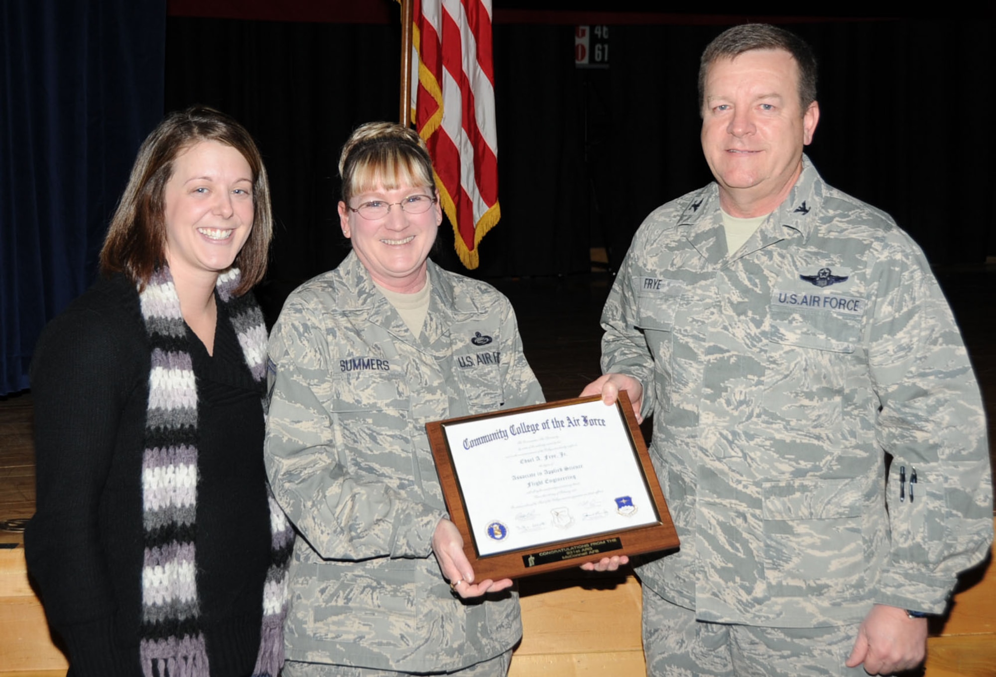Col. Edsel A. "Archie" Frye receives a framed copy of one of his Community College of the Air Force diplomas from Senior Master Sgt. Pam Summers and Staff Sgt. Kristen Adkins, of the 931st ARG, Education and Training Office. Colonel Frye cites attaining his first CCAF degree as a major turning point in his professional career. (USAF photo by Tech. Sgt. Brannen Parrish) 
