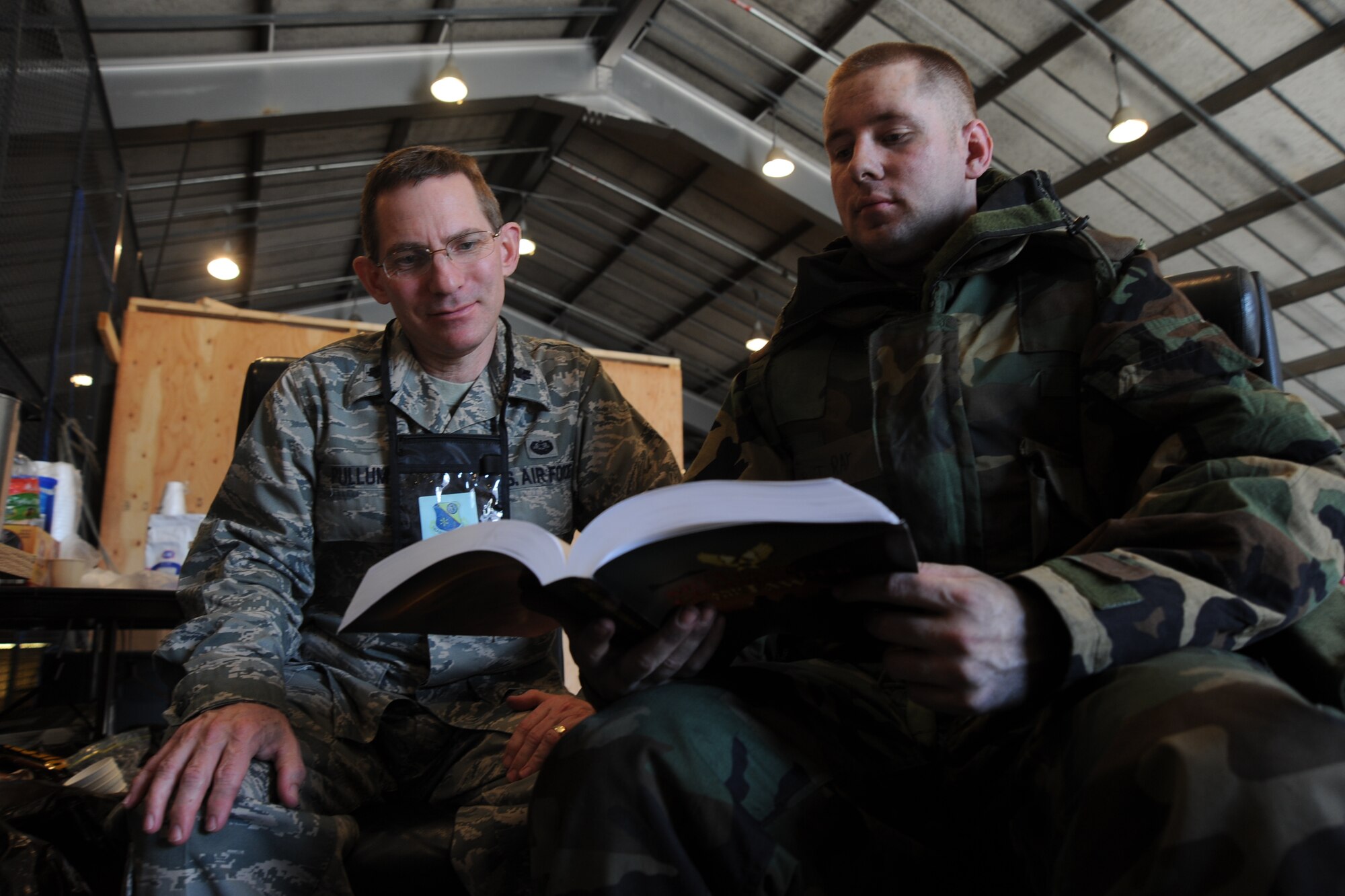 Lt. Col. Paul Pullum, 185th Air Refueling Wing deputy staff judge advocate, and Staff Sgt. Robert Ray 22nd Air Refueling Wing paralegal, review a legal publication during an operational readiness exercise, Feb. 15, 2011, McConnell Air Force Base, Kan. During the exercise, Team McConnell members simulated deploying to a location and creating a base from the ground up.  Members of the 185th ARW will partner with members of the 22nd ARW on an upcoming operation readiness inspection later this year. (U.S. Air Force photo/Staff Sgt. Dallas Edwards) 