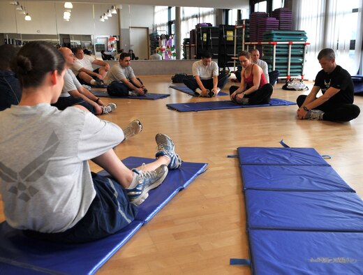 U.S. Air Force Retired Lt. Col. Gary Trautmann and his wife, Adrianna Mitchell, certified personal trainers, demonstrate proper stretches for runners during the Running for Dummies running clinic at the Health and Wellness Center, Ramstein Air Base, Germany, Feb. 23, 2011.  Running for Dummies is a class dedicated to helping people learn to run safely and properly.  For more information contact the Ramstein HAWC. (U.S. Air Force photo by Senior Airman Caleb Pierce)